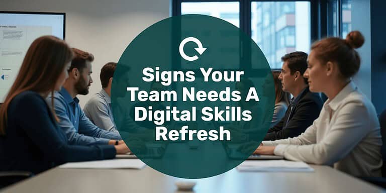 A group of employees using their computers at a large table with text overlay "signs your team needs a digital skills refresh."